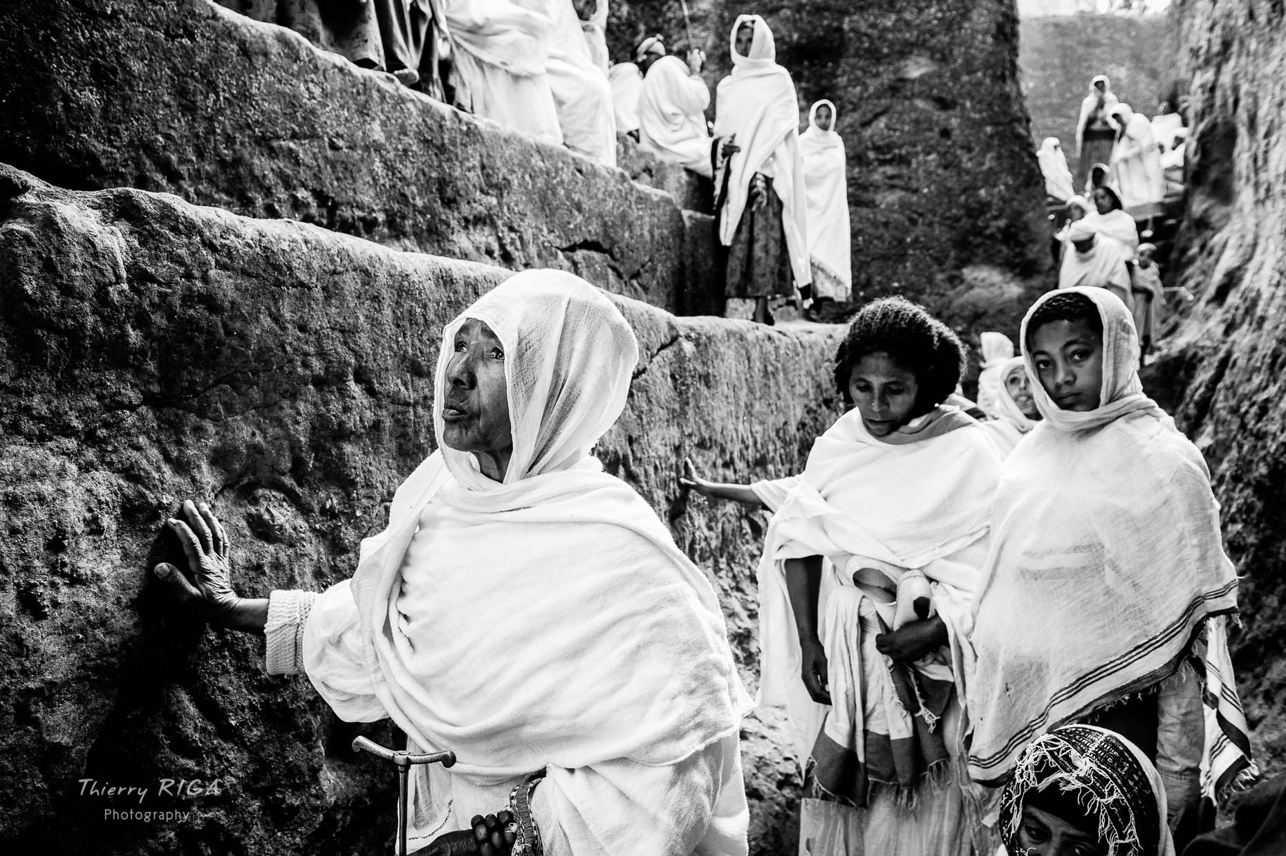 Women in white worshipping in Golgotha Michael trench, Lalibela, Ethiopia, Thierry Riga