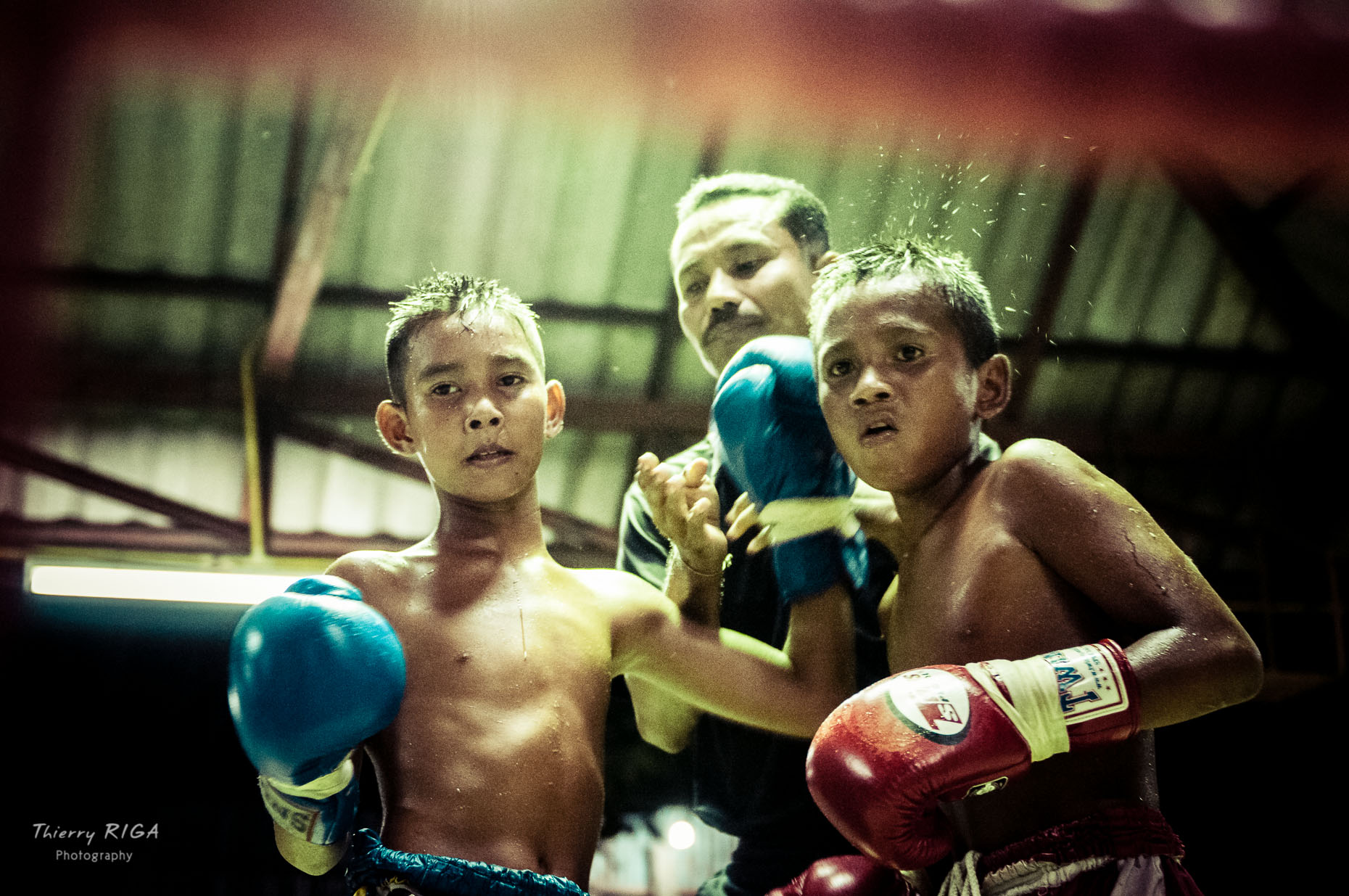 kids boxing Muay Thai in thailand, at the end of the round