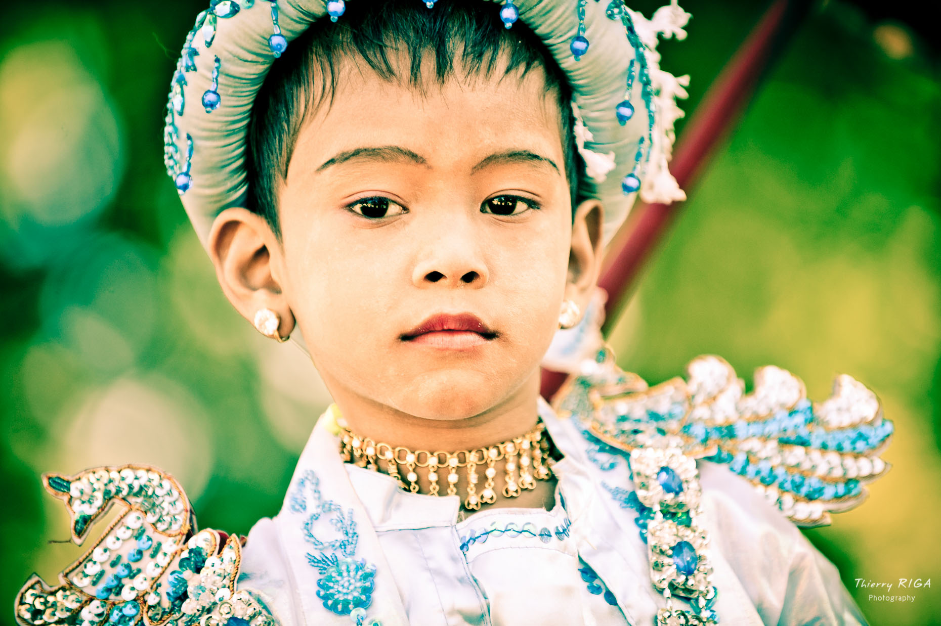 Novice dressed in blue riding a horse during ordination ceremony in Bagan, Myanmar